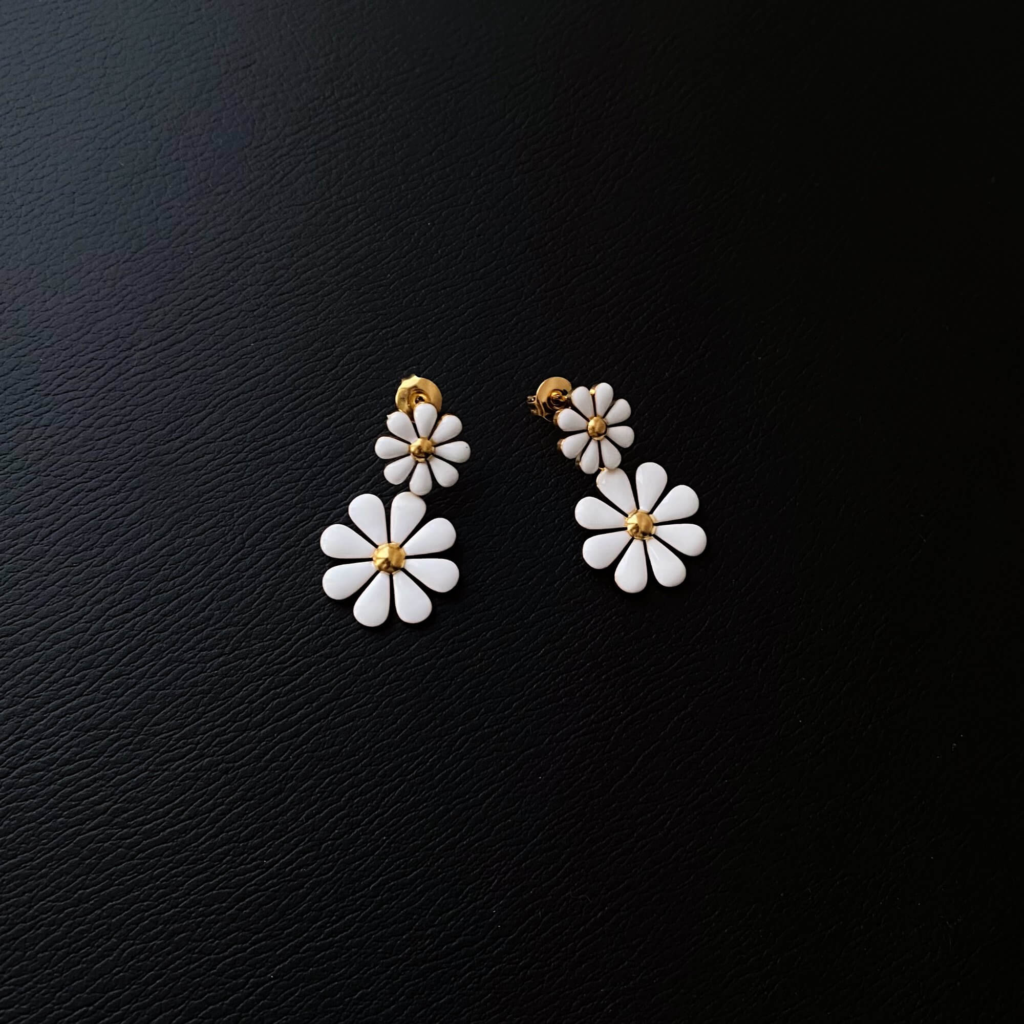 Flat lay of KendyR daisy drop earrings by Kampy Designs, neatly displayed to showcase petal detail and color contrast.