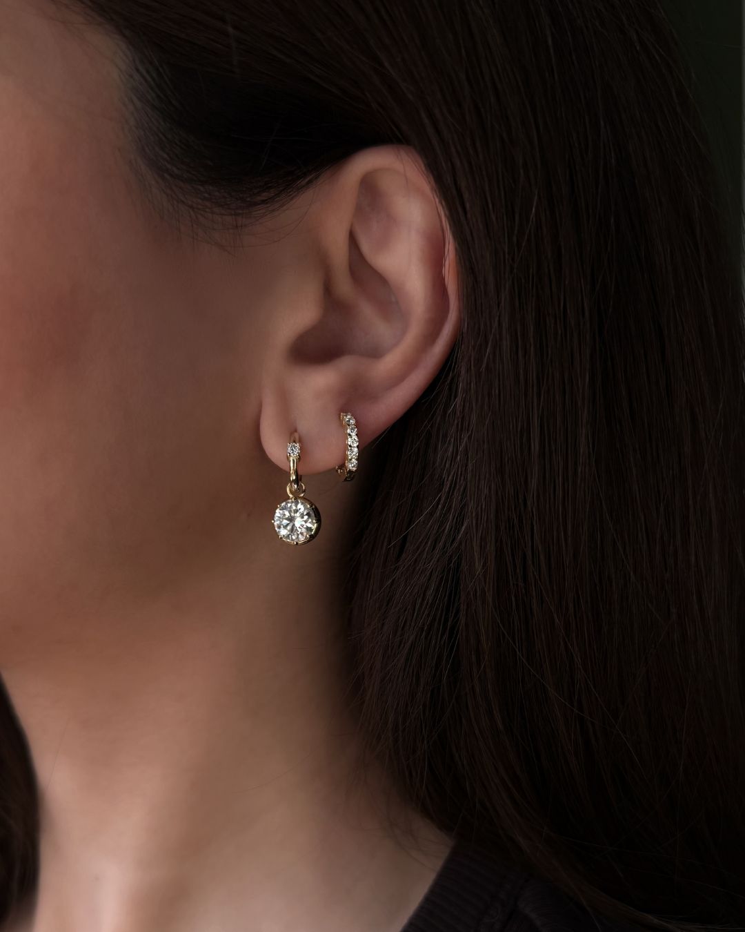 model wearing drop earrings stacked with diamond hoop earrings