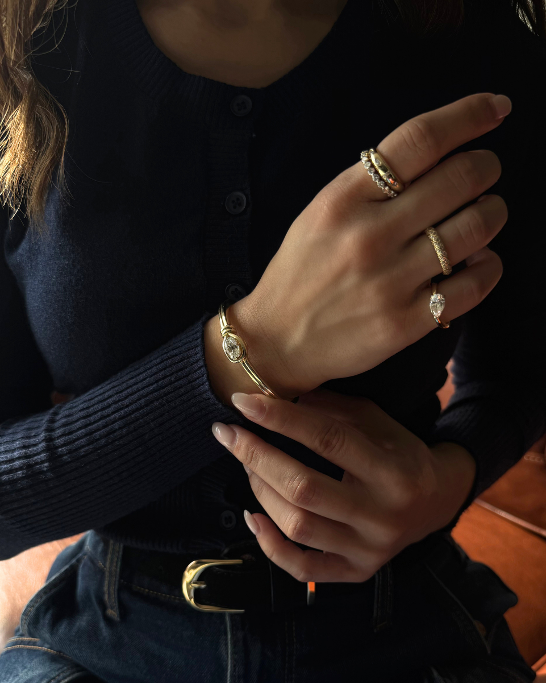 Elara elongated cushion moissanite knot bangle styled with moissanite rings in 14K gold over 925 sterling silver, modern fine jewelry look.