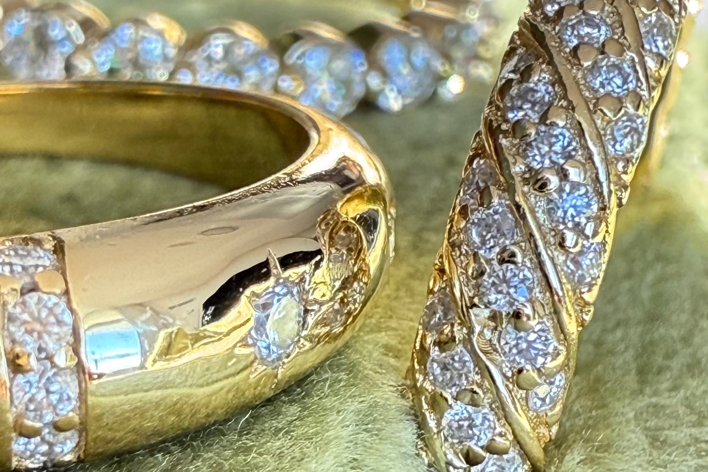 Close-up of gold rings with diamond accents on a gold surface