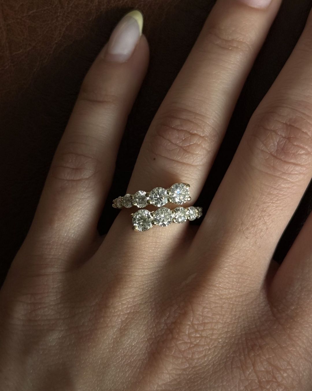 Gold moissanite open wrap statement ring worn on hand with close-up stone detail.