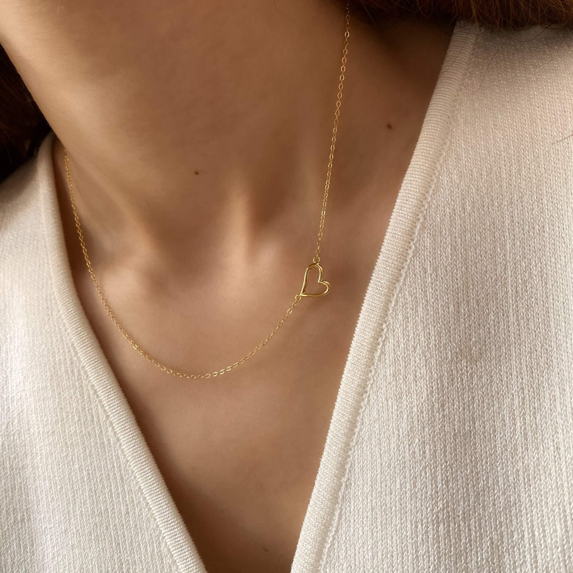 Side view of the KieraN hollow heart charm pendant necklace by Kampy Designs, showcasing its delicate heart-shaped design with a polished gold finish.