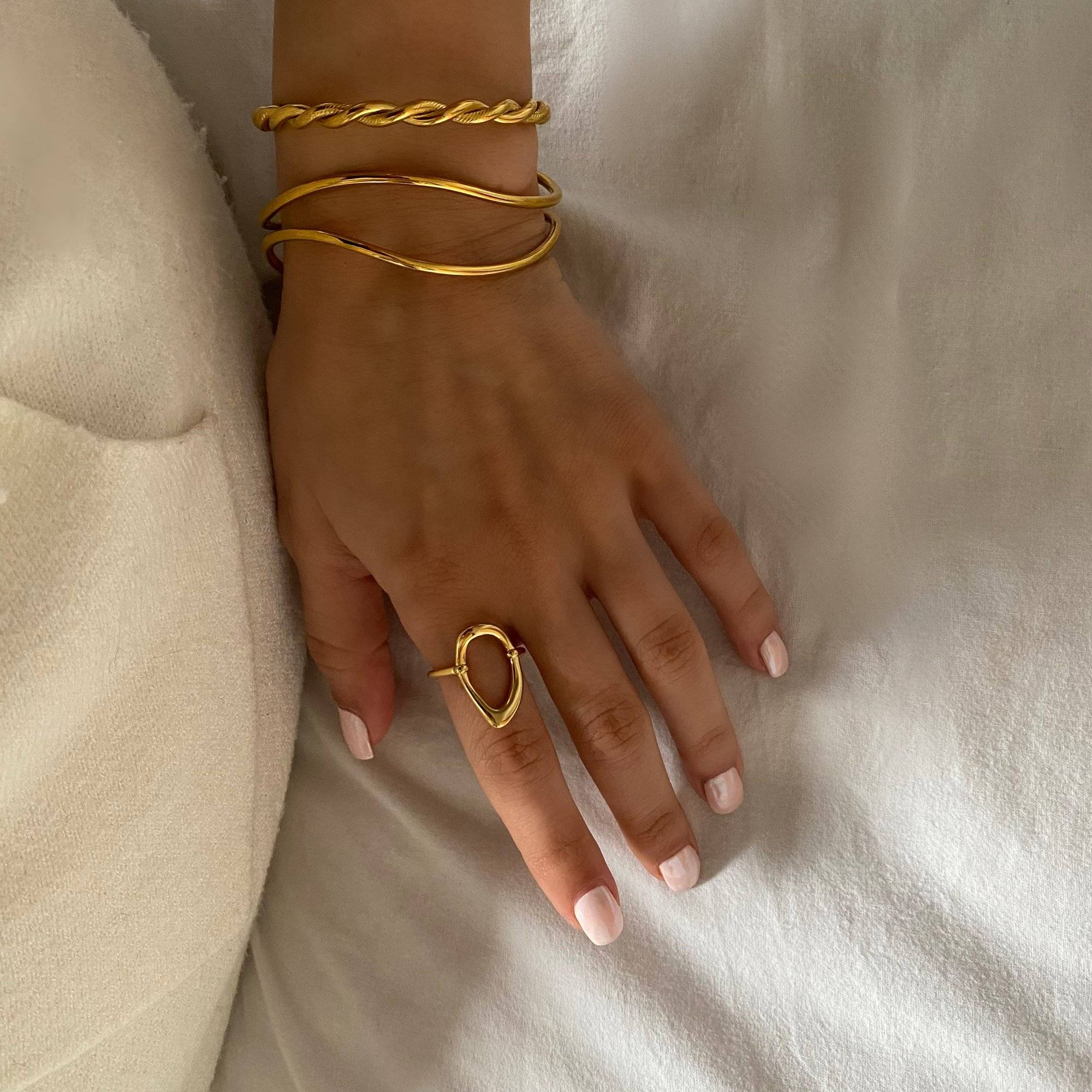 KatyR hollow oval ring by Kampy Designs styled with bracelets on model, offering a layered jewelry look.