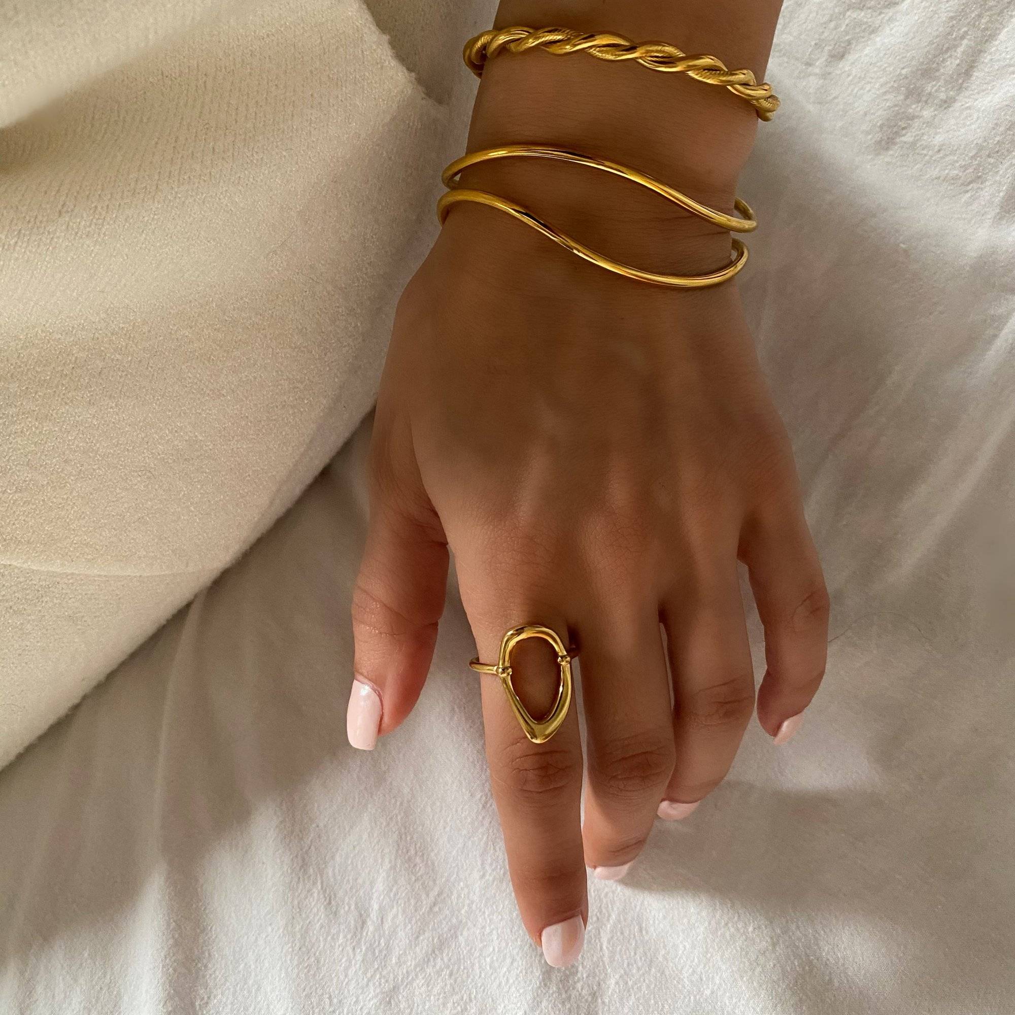 Styled flat presentation of the KatyR hollow oval ring by Kampy Designs, combining minimal form with a modern edge.