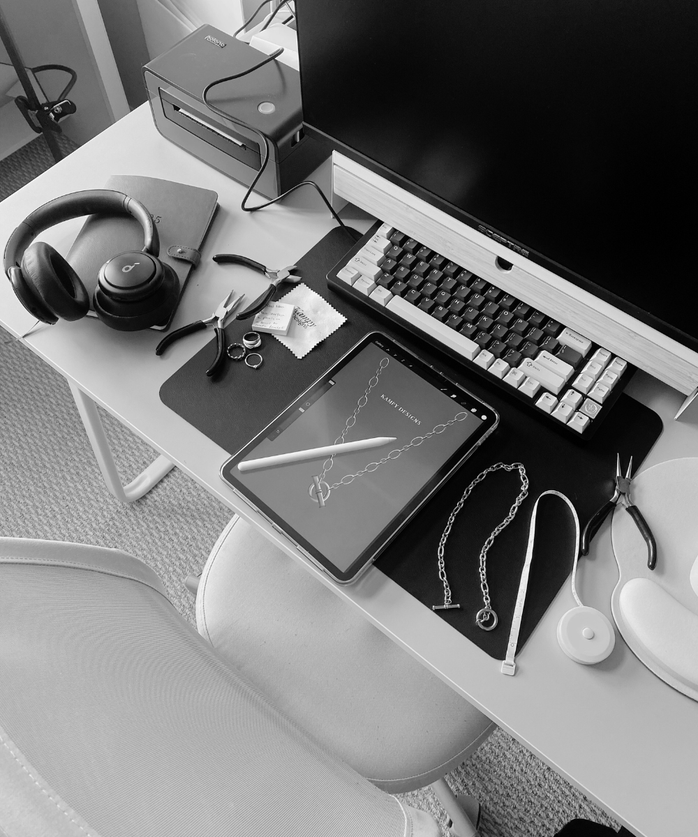 Black and white office desk with computer, tablet, and various items.