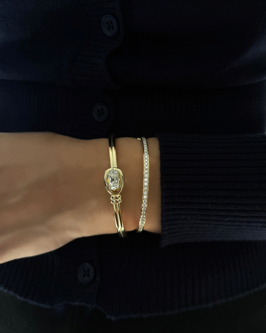 Lara moissanite tennis eternity bangle stacked with sculptural knot bangle in 14K gold over 925 sterling silver for modern layered styling.