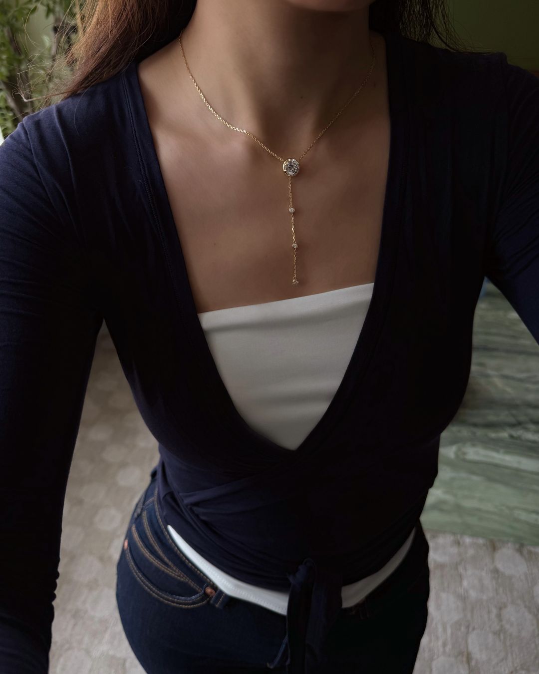 Lumina Drop Necklace styled with a navy and white outfit, showing the full lariat silhouette and 3 ct moissanite center stone.