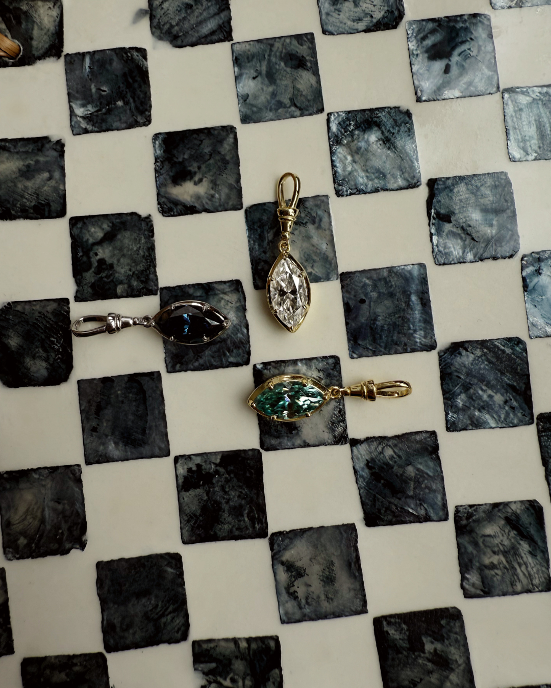 Marquise moissanite pendant necklace showing green, clear, and blue stone color variations in gold and silver settings by Kampy.