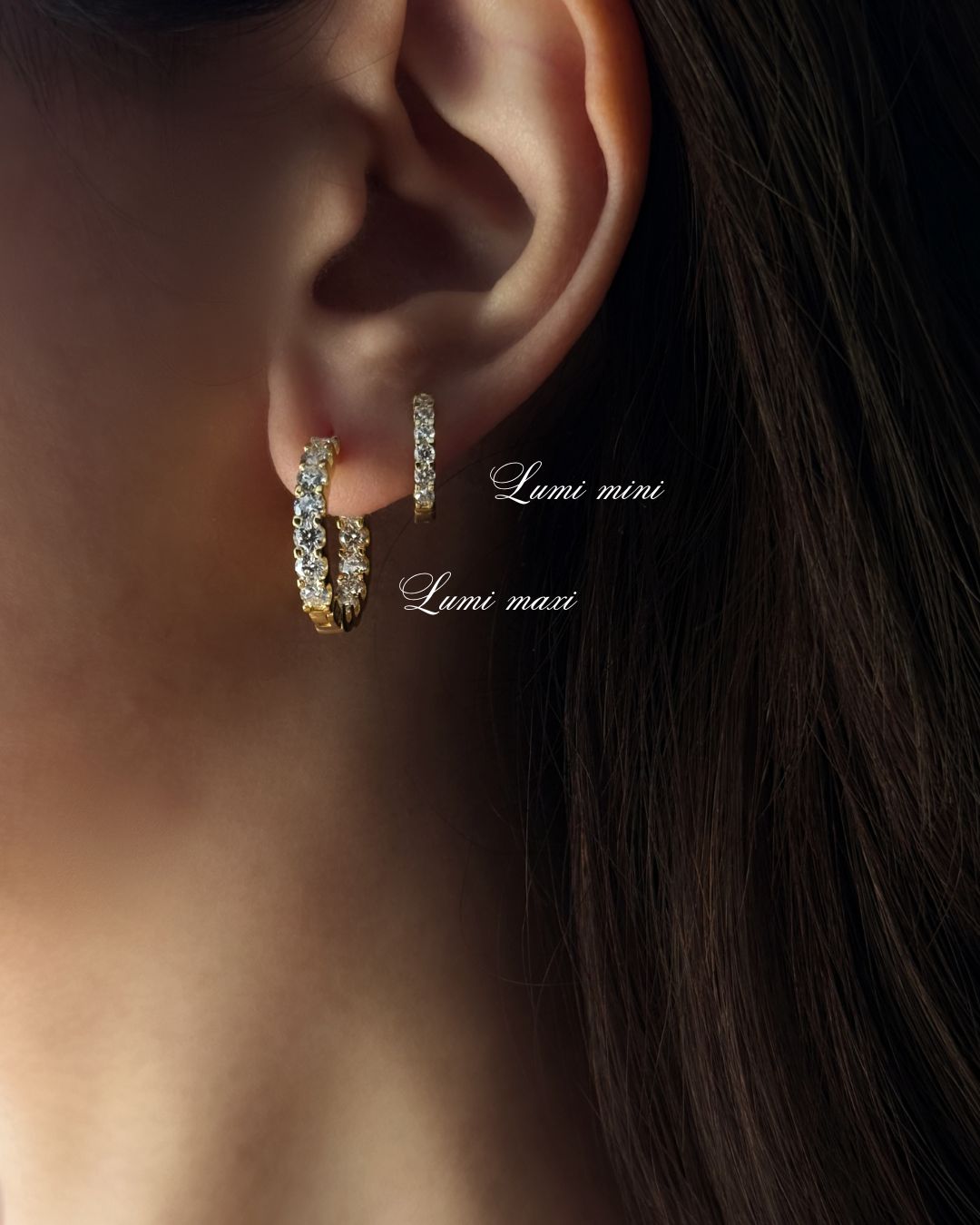 Gold moissanite hoop earring stack shown on ear with 14 mm and 20 mm sparkling huggie hoops by Kampy Designs.