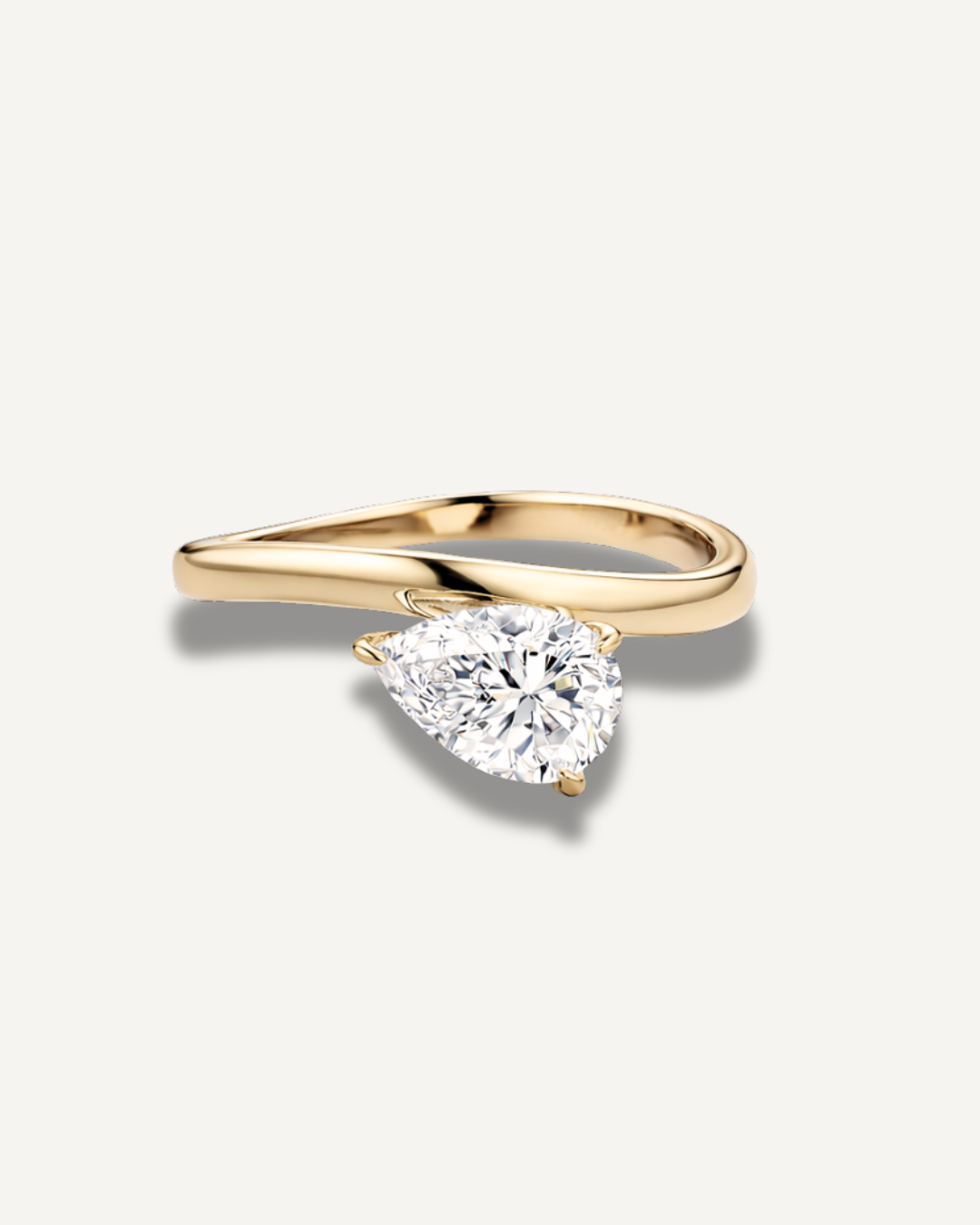 East-west pear cut moissanite wave ring in gold finish on neutral background, Kampy Designs