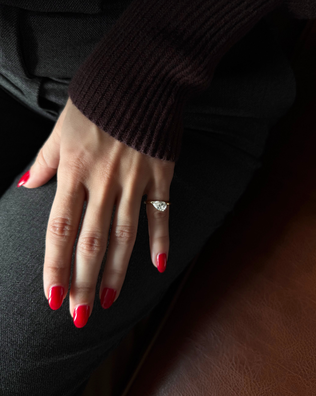 Top view of east-west pear cut moissanite wave ring worn on model pinky, Kampy Designs