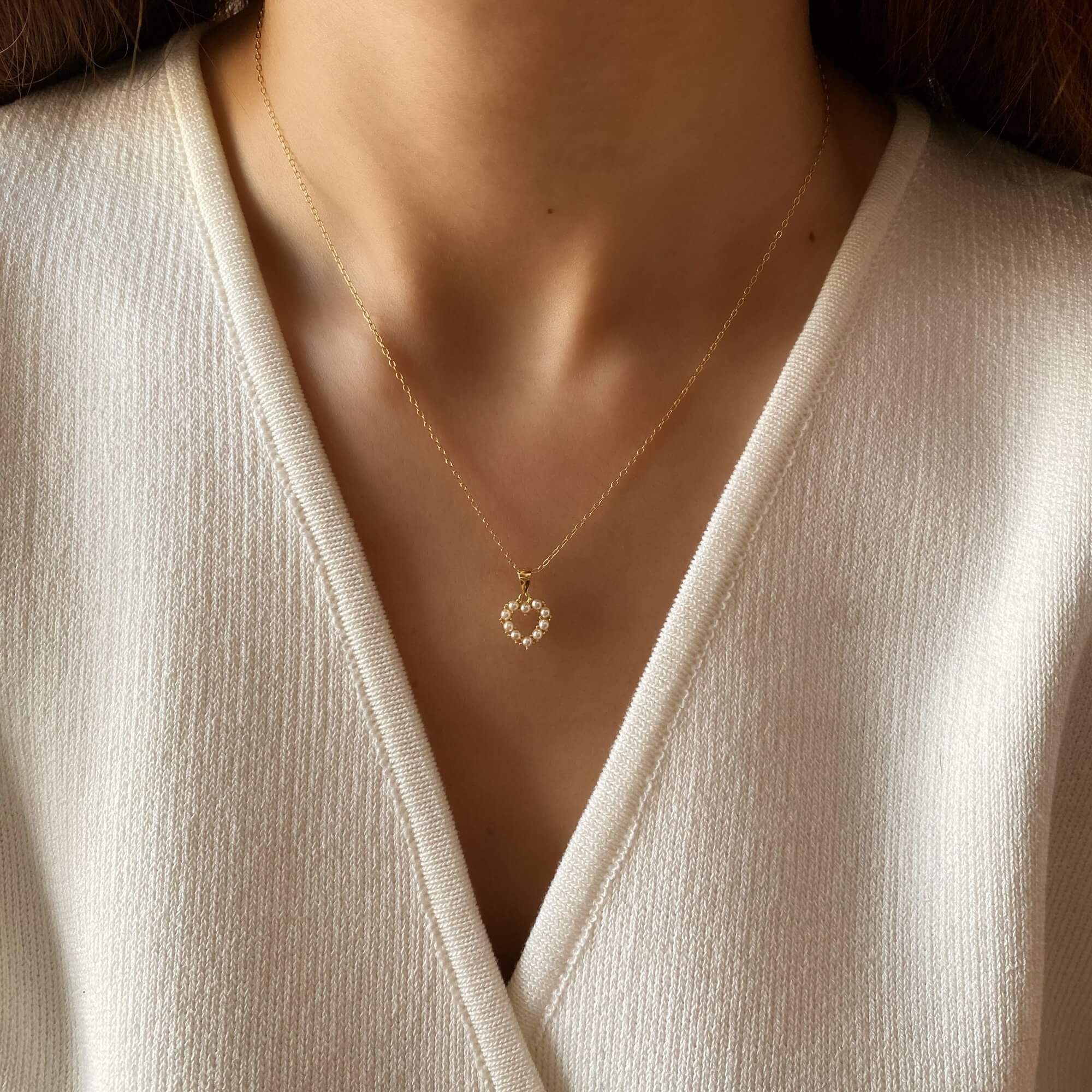 The KenaN pearl heart pendant necklace by Kampy Designs, elegantly worn, showcasing its delicate heart design and luminous pearl centerpiece.