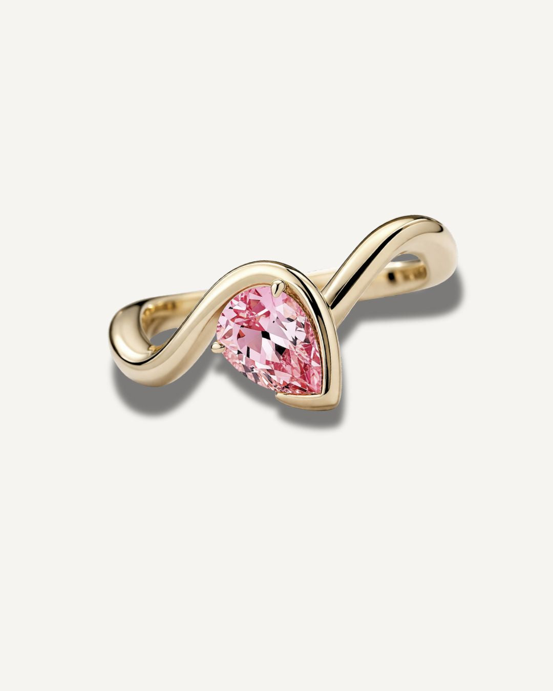 Gold wave band pinky ring with pear cut pink sapphire gemstone in a clean front-facing product view