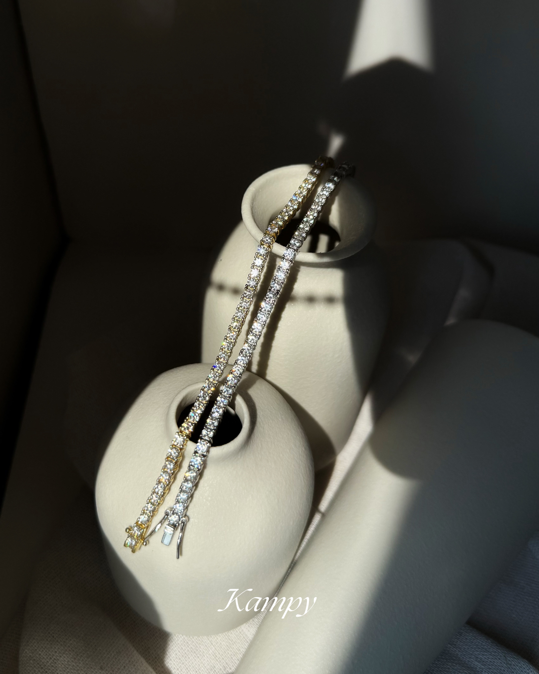 tennis bracelets on a white ceramic vase with 'Kampy' branding.