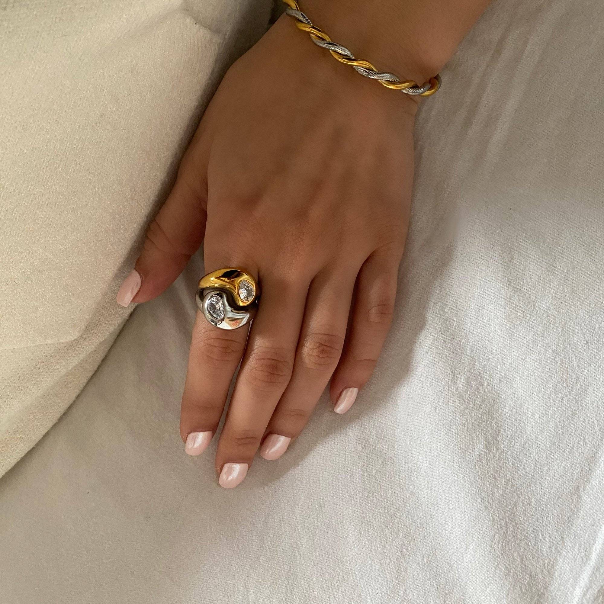 Styled product shot of KangR two-toned yin yang ring by Kampy Designs, displayed in a minimal, elegant setting.