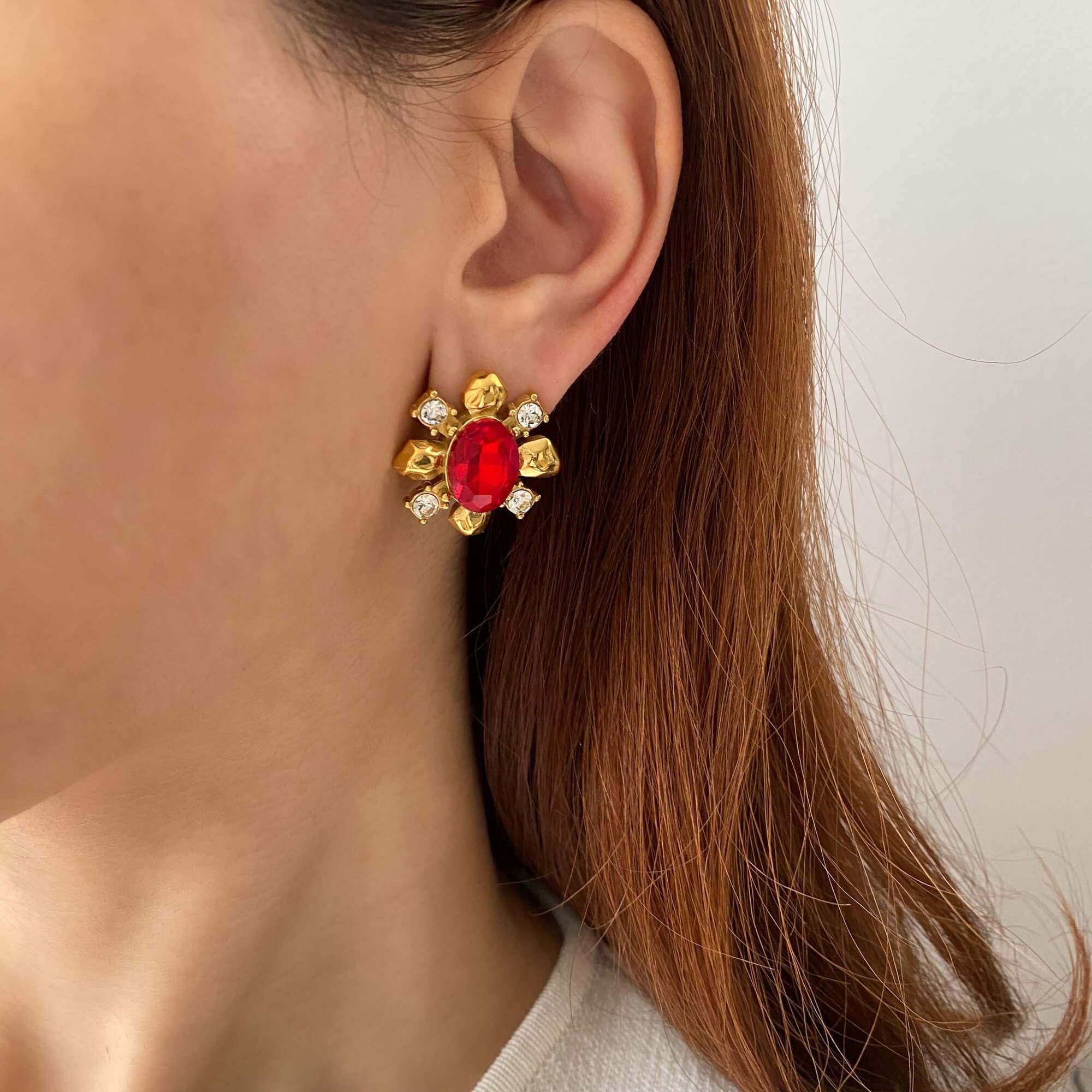 Close-up of the KarnaraE vintage garnet stud earrings by Kampy Designs, worn on a model, showcasing their deep red gemstone and elegant design.