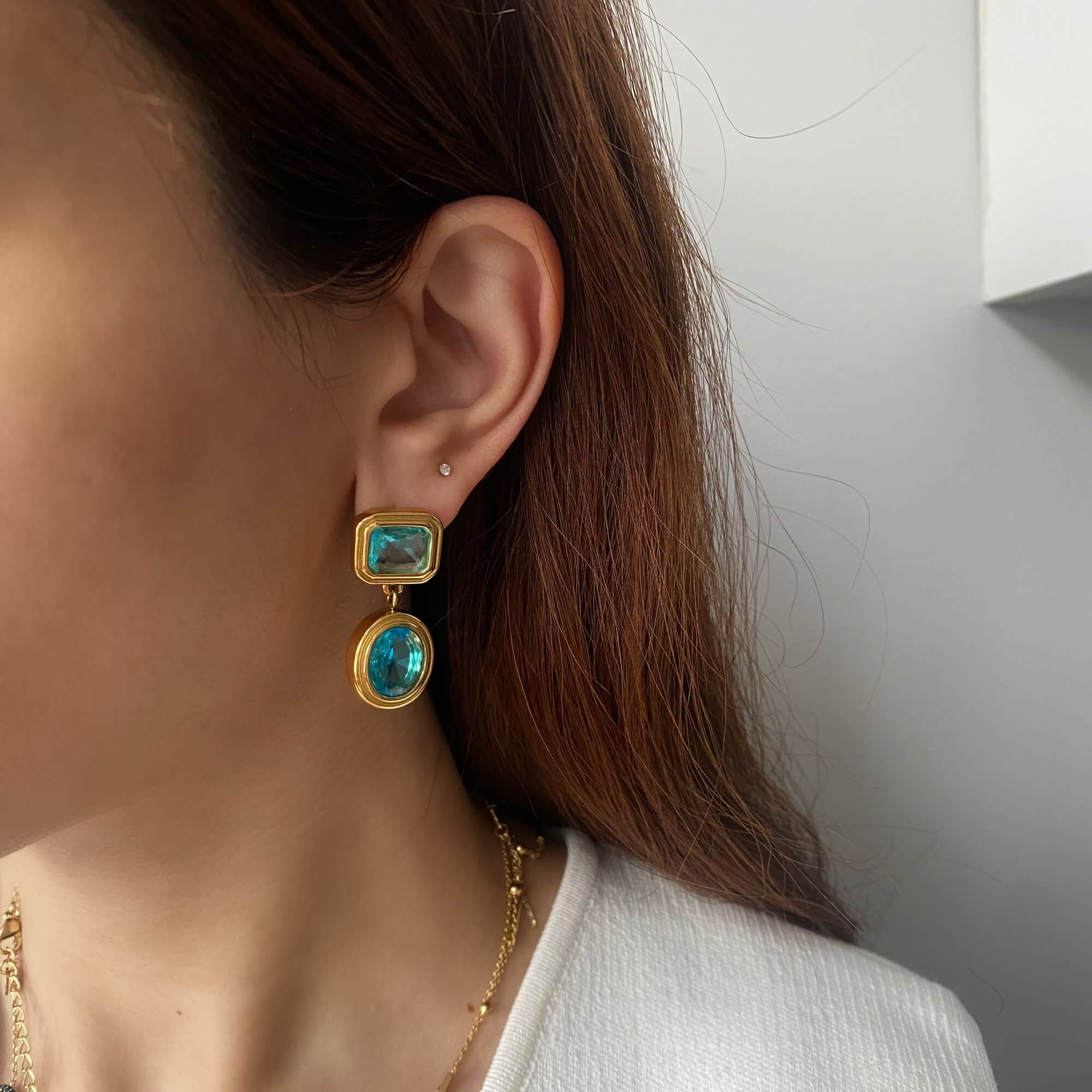 Aquamarine KosaE vintage-inspired dangle earrings by Kampy Designs, worn on model's ear to showcase the drop length and elegant blue hue.