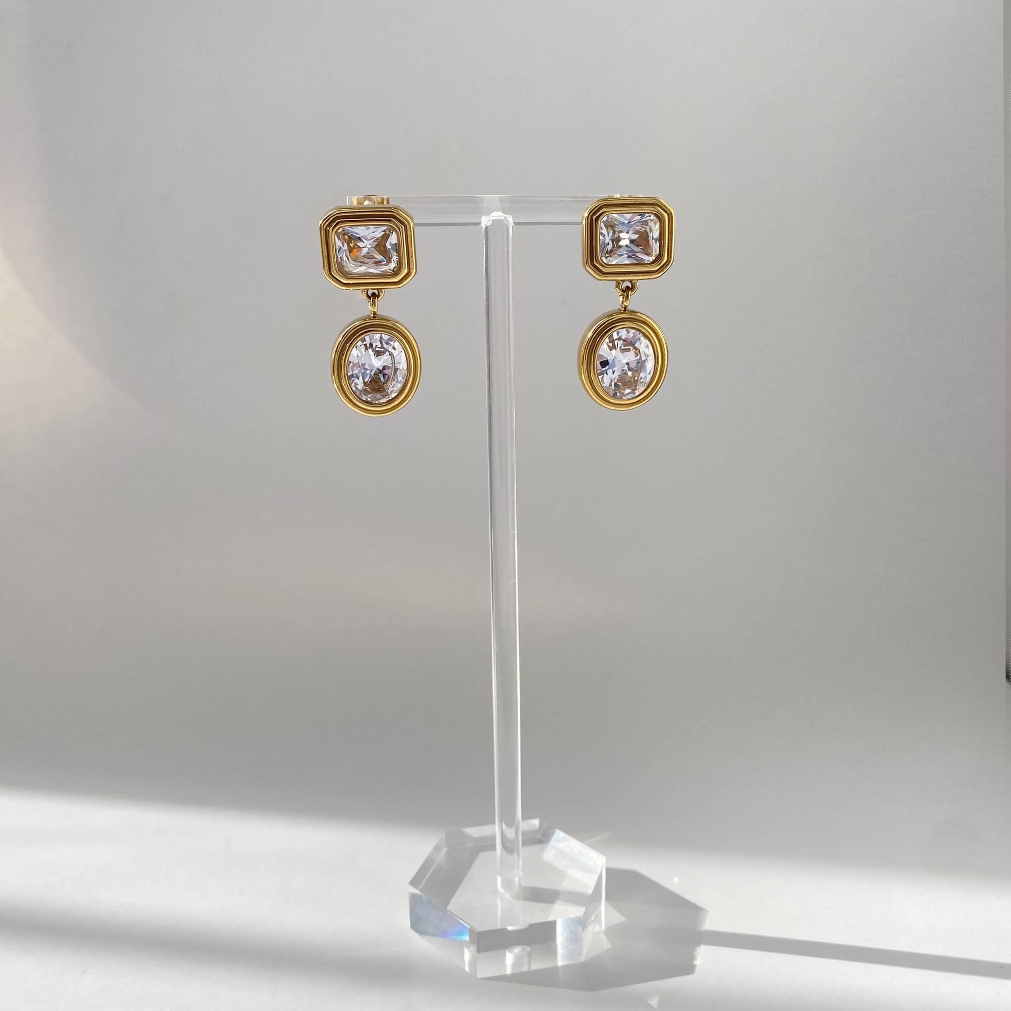 Front view of KosaE vintage-inspired dangle earrings by Kampy Designs in clear crystal finish, featuring timeless drop and gold-tone filigree.
